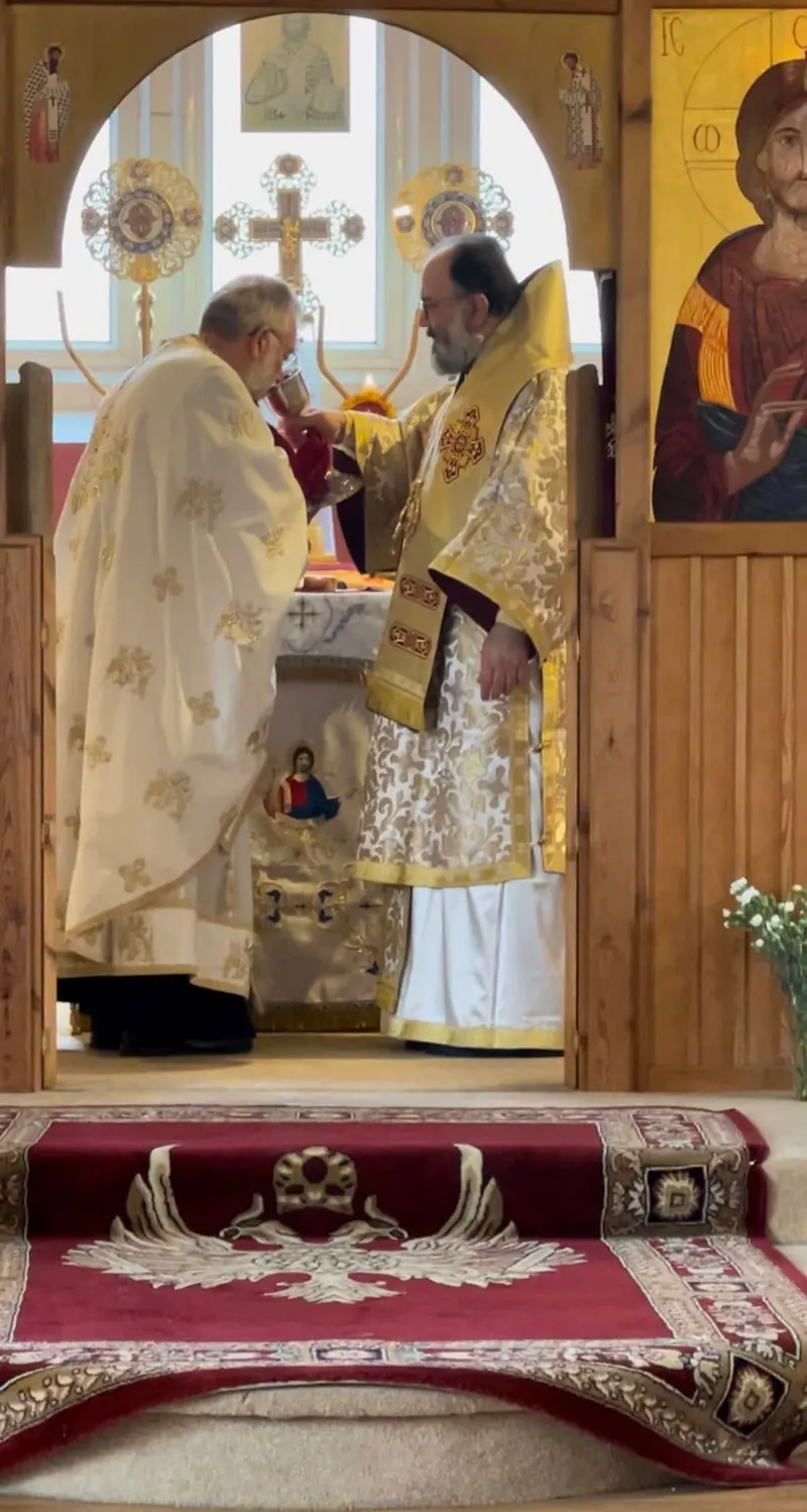 Two priests at the altar of our church, seen through the royal doors